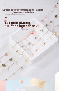 Detail of 14k gold-filled jewelry chains with vibrant strawberry crystal beads and stones