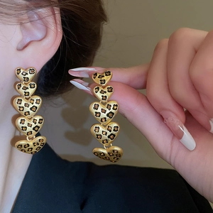 Detail der Vintage-Herzohrringe mit Leopardenmuster, Goldfinish und Nietenbesatz