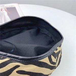 Dettaglio del berretto con stampa zebrata, trama in twill e bordo in pelle nera rifinita
