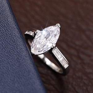 Macro shot of marquise-cut crystal ring with baguette side stones on a jewelry box