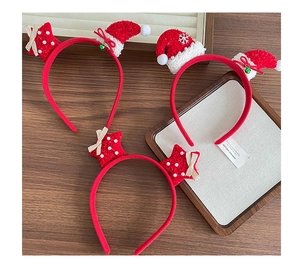 Detail of Christmas headbands with mini Santa hat, red stars, and festive bows on wood