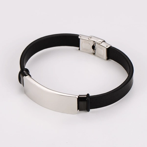 Dettaglio ravvicinato di un bracciale in pelle nera con piastra in metallo argento lucido