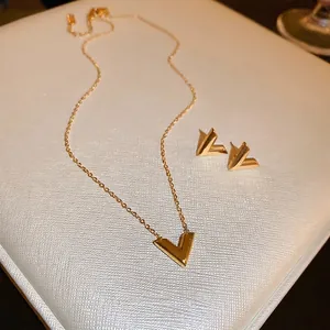 Ensemble collier et boucles d'oreilles dorés en forme de V avec finition métallique