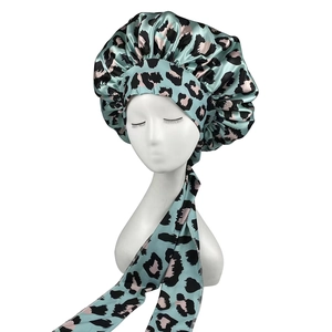 Mint green leopard print satin hair bonnet with long ties on a white background