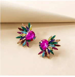 Macro shot of bohemian rhinestone earrings with a teardrop pink gem and colorful crystals