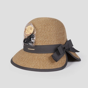 Detail of sun hat showing natural fiber texture, bow ribbon, and UPF 50+ wind rope accessory