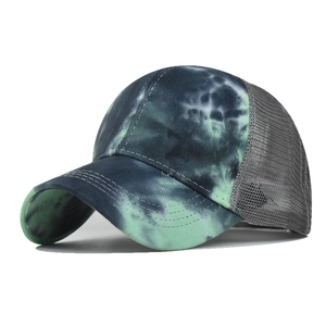 Detailed top view of tie-dye mesh trucker hat with black green pattern and curved brim