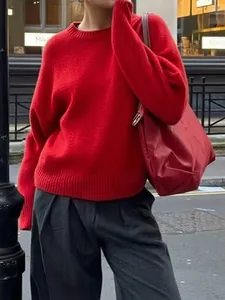 Women's minimalist red crew neck long sleeve sweater paired with grey wide-leg trousers