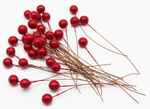 Close-up of artificial red berries with brown stems for home decor and DIY crafts