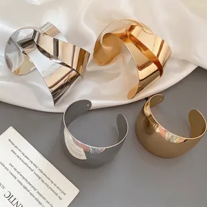 Set of four minimalist high-polish metal knot open bangles in gold and silver finish