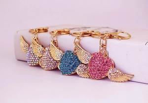 Detailed view of four heart-shaped crystal wings keychains in various vibrant colors