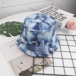 Detail of double-sided denim print bucket hat with retro distressed graffiti patterns