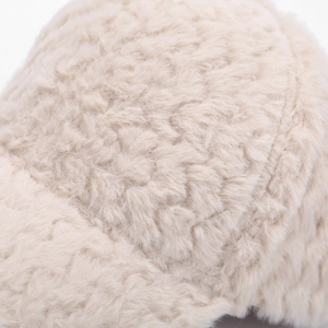 Macro detail shot showing the soft, thick plush texture of the beige baseball cap.