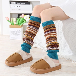 Détail de jambières en tricot à rayures colorées portées avec des chaussons doux