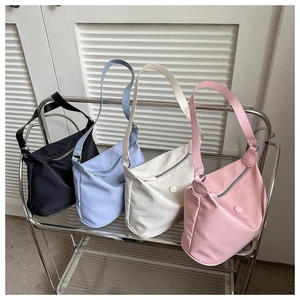 Moderne minimalistische Schultertaschen in verschiedenen Farben auf einem Stahlregal