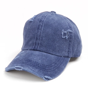 Detail of washed denim baseball cap featuring vintage distressed holes and frayed edges
