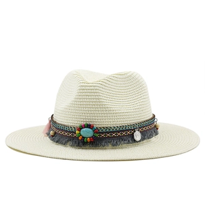 Detail of bohemian straw sun hat featuring ethnic colorful tassels and turquoise beads