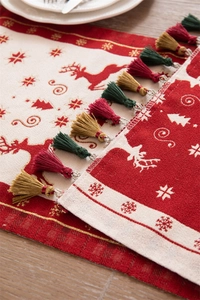 Close-up of jacquard Christmas table runner with reindeer motifs and tassel details