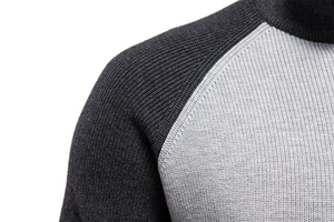 Macro shot of two-tone grey knit fabric showing detailed raglan sleeve stitching