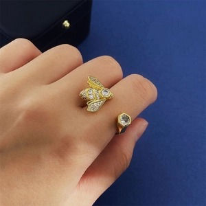 Detail of a golden bee ring with sparkling zircons worn on a finger in macro view