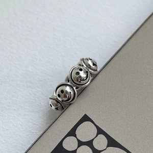 Detailed view of vintage 925 silver ring featuring embossed smiley faces and oxidized finish