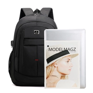 Large black business backpack with laptop and magazine on white background
