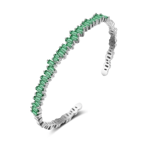 Detail view of silver open bracelet with emerald-green baguette zircon stones