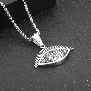 Detailed view of silver evil eye turtle pendant with embossed dots on a sturdy box chain