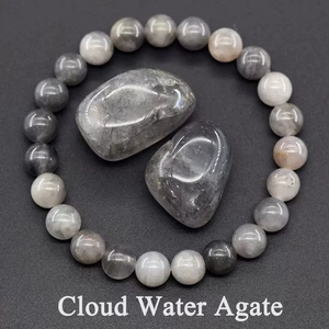 Macro detail of natural grey Cloud Water Agate beaded bracelet and polished raw stones