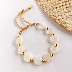Detail of adjustable heart bead chain bracelet with gold accents and woven cord strap