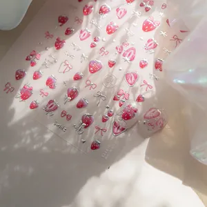 Detail of pink strawberry nail stickers with bows and metallic silver heart accents