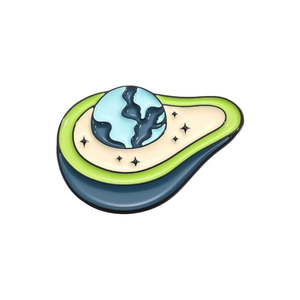 Macro detail of avocado enamel pin with Earth globe core and small black stars