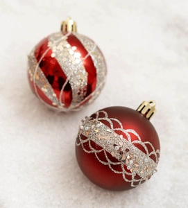 Détails de boules de Noël rouges et dorées avec rayures scintillantes et motifs dentelle