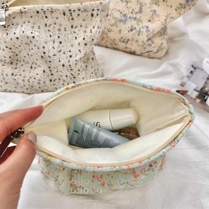 Close-up of hand opening the floral embroidery canvas makeup bag with large capacity