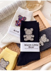 Detailed view of ribbed cotton crew socks featuring a sparkling rhinestone bear patch