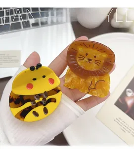 Detail of acetate hair claws in cute bee and lion shapes with a high-quality finish