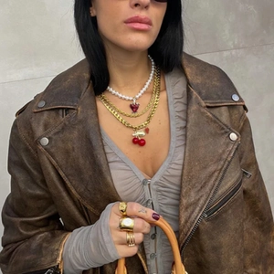 Layered gold necklaces with white pearls and red heart pendant worn by model