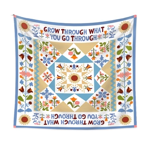 Close-up of bohemian floral tapestry with Grow Through What You Go Through text