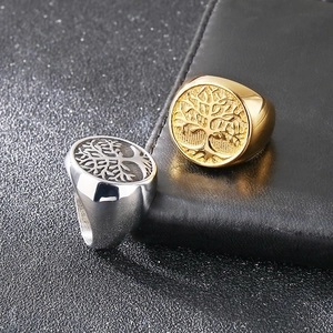 Detail of gold and silver signet rings featuring Tree of Life relief and polished finish