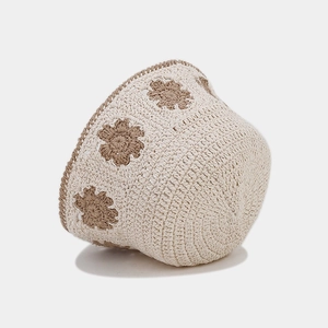 Close-up of crochet hollow flower pattern on beige bucket hat with brown floral details