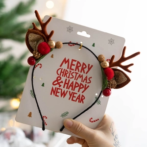 Detailed close-up of a Christmas reindeer antler headband with festive ornaments and packaging