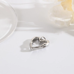 Macro shot of silver heart pendant with textured surface and 18k gold plating details