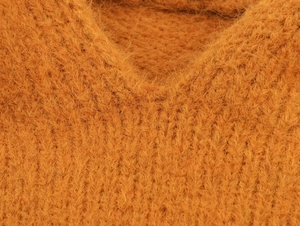 Gros plan sur un pull en mohair orange avec col en V doux et texture laineuse dense