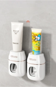 Wall-mounted automatic toothpaste dispenser with rose gold trim for adults and kids