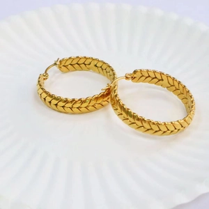 Macro shot of 18K gold plated stainless steel hoop earrings with wheat ear texture