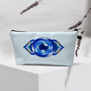 Detailed view of light blue Evil Eye makeup bag on a white geometric stand with lavender