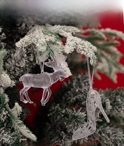 Ornements renne et talon haut transparents sur un sapin de Noël enneigé
