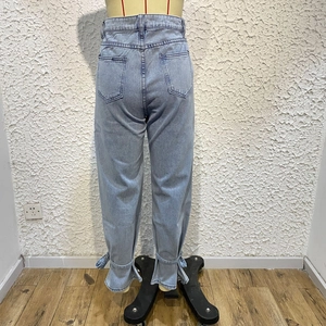 Detail view of light blue straight denim jeans with lace-up hem and back pocket structure
