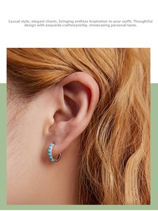 Close-up of a 925 silver hoop earring set with turquoise beads on a model ear