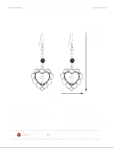 Detail view of retro hollow heart earrings with cross pattern and black bead accent